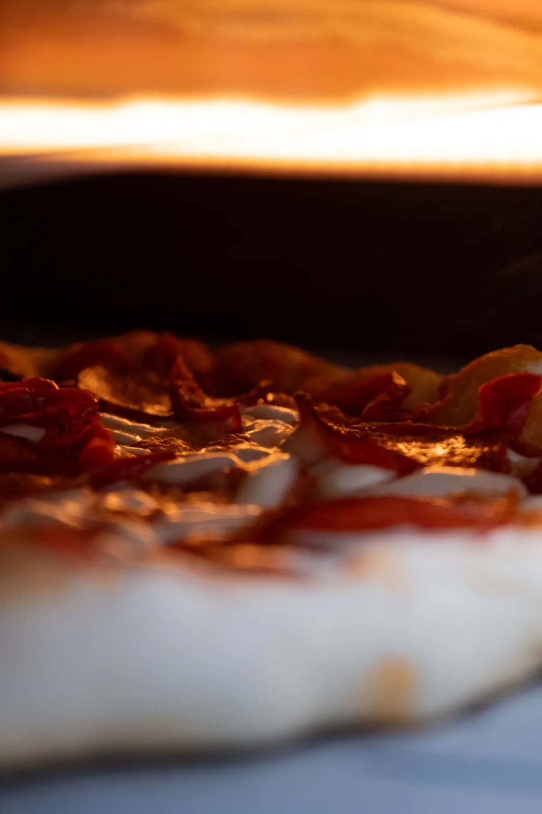 A close crop of a pizza, tomato and basil