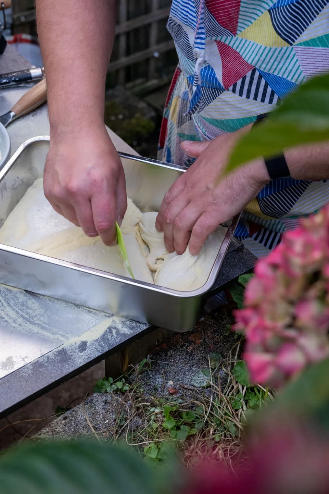 Dividing three-day dough in the tray with a scraper